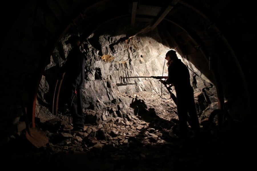 Przewodnik pokazuje zwiedzającym podziemny tunel w Kopalni Uranu w Kowarach