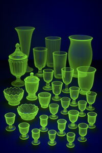 Szkło uranowe świecące na zielono pod światłem UV – naczynia w ciemnym otoczeniu